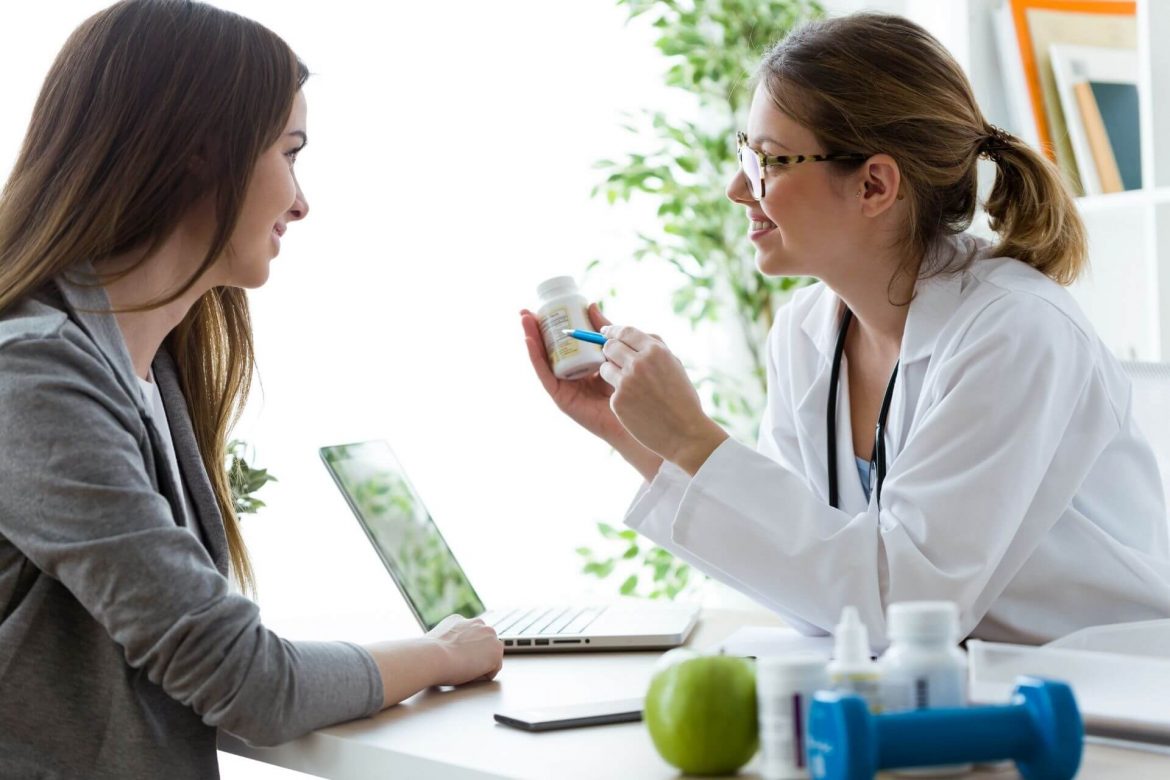 Ärztin erklärt Patientin Einnahme